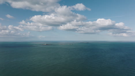 4K-Wide-Aerial-Approaching-Farne-Island-Lighthouse,-United-Kingdom-on-a-sunny-afternoon