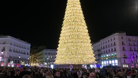 Tilt-down-shot-of-an-Illuminated-Christmas-tree-installation-decorated-with-gold-LED-lights-during-the-Christmas-season-at-Puerta-del-Sol-Square-in-Madrid