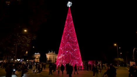 Se-Ve-Gente-Alrededor-De-Una-Instalación-De-árbol-De-Navidad-Decorada-Con-Luces-LED-Rojas-Para-Las-Festividades-Navideñas.
