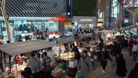 Mercado-Nocturno-De-Myeongdong-En-Seúl:-Fila-De-Puestos-De-Comida-Callejera-Que-Venden-Bocadillos-Y-Cocina-Coreana-A-La-Parrilla-En-El-Distrito-Comercial-Peatonal