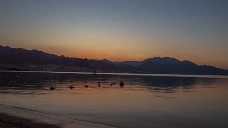 Sun-rises-from-behind-mountains-and-shines-and-beautiful-lake,-time-lapse