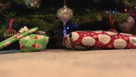 Low-angle-shot-of-some-presents-wrapped-sitting-under-a-Christmas-tree