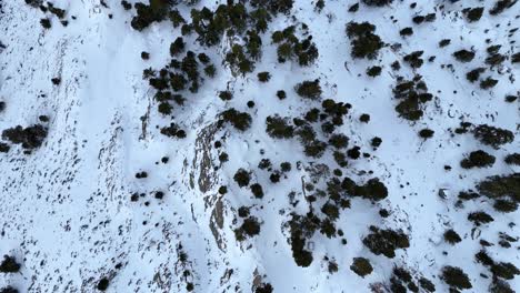 Top-down-drone-footage-of-a-mountain-refuge-under-the-snow-at-dawn-in-the-Pyrenees-mountains