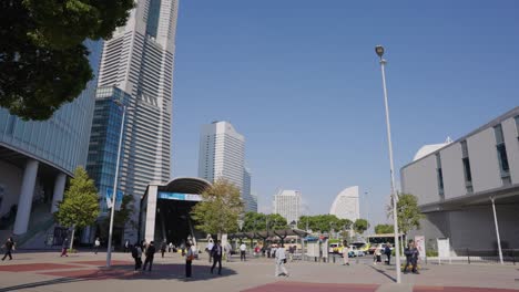 Slow-motion-Pan-over-Yokohama-Bay-Area-Station,-Sunny-Day-with-Landmark-Tower-Background