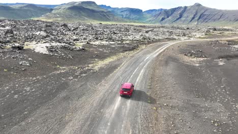 Siguiendo-Un-Coche-Rojo-Conduciendo-Por-El-Camino-De-Tierra-A-Lo-Largo-Del-Campo-De-Lava-Berserkjahraun-En-La-Península-De-Snaefellsnes-En-Islandia