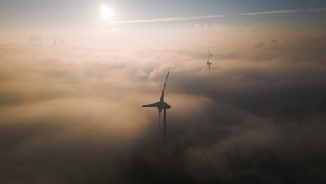 Windmill-Turbines-Above-Sunny-Early-Morning-Fog-Layer-AERIAL