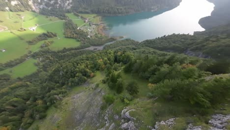 Fliegen-Sie-In-Der-Nähe-Schroffer-Bergrückengipfel-Und-Grüner-Waldbelaubung-Und-Erreichen-Sie-Den-Malerischen-See