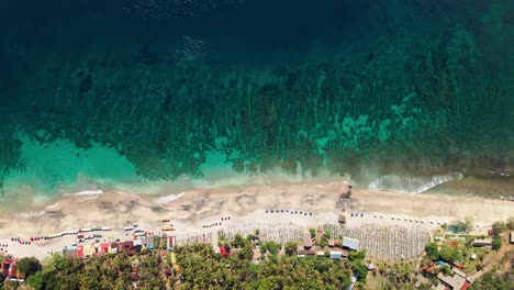 Top-view-of-the-beautiful-beach-and-ocean-bottom-texture-relief-with-green-waters-in-Bali,-Karangasem,-Indonesia