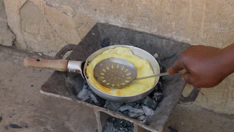 Making-an-egg-omelet-on-a-charcoal-stove,-with-banku-as-a-side-dish