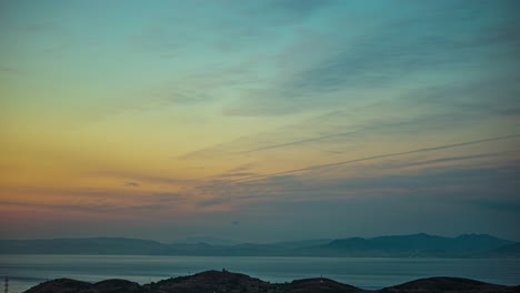 Atemberaubender-Abendsonnenuntergang-über-Der-Dunstigen-Meereslandschaft-Und-Dem-Bergigen-Horizont
