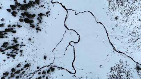 Top-down-drone-footage-of-a-frozen-river-in-the-Pyrenees-mountains