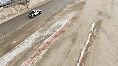 A-side-street-covered-in-strewn-sand-from-a-Winter-Storm