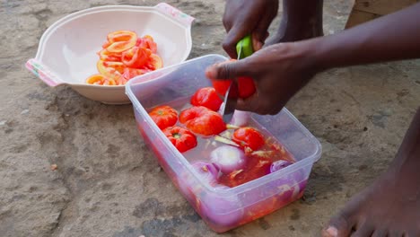Woman-washes-and-cuts-peppers-for-the-sauce-that-accompanies-banku