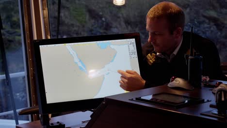 Capitán-Mostrando-Viaje-A-Través-Del-Mar-Rojo-Y-Yemen-En-Un-Mapa-Electrónico,-Preocupado