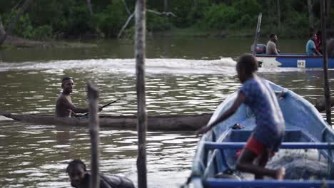 Ein-Junge-Aus-Der-Papuanischen-Volksgruppe-Rudert-Mit-Einem-Boot-Und-Landet-Am-Rande-Eines-Flusses-In-Asmat,-Papua