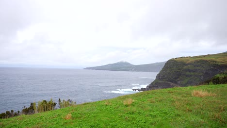 Green-meadow-coastline-over-calm-Atlantic-Ocean-in-Faial,-Azores