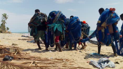 African-people-picking-up-fishing-nets-on-a-beach