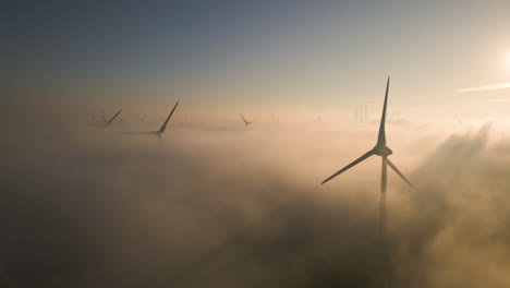 Cinematic-aerial-view-of-wind-turbines-in-the-misty-sky-at-sunrise