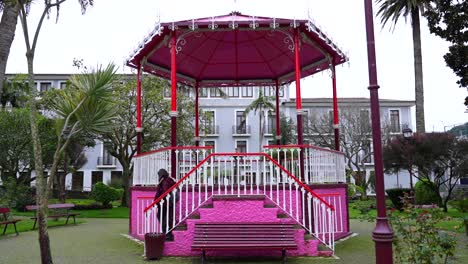 Woman-visits-the-pink-kiosk-of-the-botanical-Jardim-Duque-da-Terceira