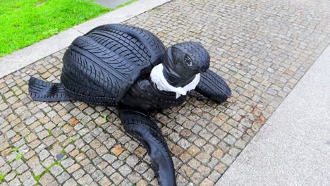Turtle-made-of-car-tires-with-plastic-around-its-neck,-environment-awareness