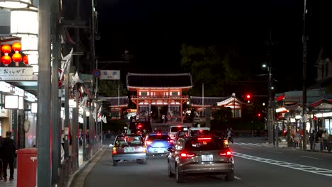 Verkehr-Entlang-Shijo-Dori-Bei-Nacht-Mit-Nishiro-Mon-Tor-Im-Hintergrund-In-Kyoto