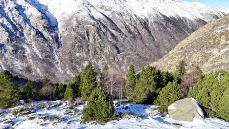 Drone-footage-revealing-a-green-and-snowy-valley-in-the-Pyrenees-mountains