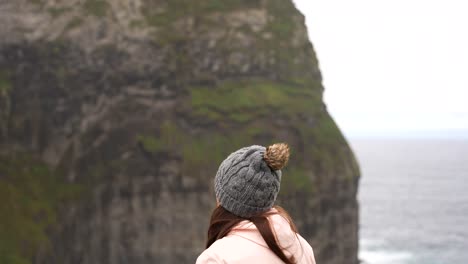 Woman-getting-colder-visiting-Morro-do-Castelo-Branco-with-a-pink-jacket-and-grey-beanie