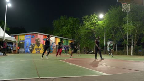 Basketballmannschaft-Spielt-Nachts-In-Afrika-Im-Freien-Zusammen,-Schwarze,-Männliche,-Fitte-Spieler