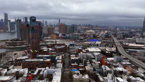 An-aerial-view-over-Greenpoint,-Brooklyn-in-NY-with-Long-Island-City-and-NYC-in-the-background-on-a-cloudy-day