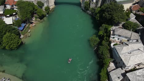 Drone-view-of-Mostar-Bridge-the-historical-architecture,-people-visiting-the-tourist-bridge