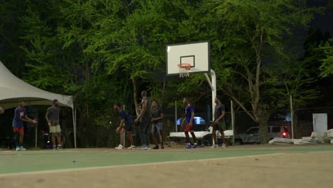 Low-angle-shot-of-basketball-black-dream-team-of-friends-play-together-at-night