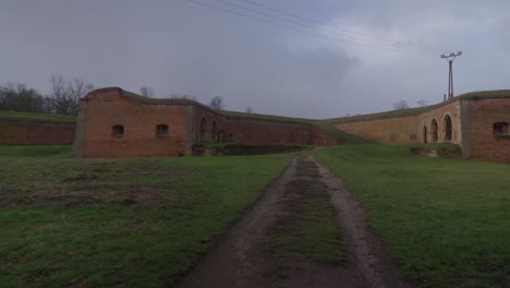 A-grassy-area-bordered-by-the-brick-walls-of-the-Terezín-Fortress