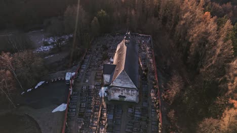 Drone's-descending-camera-reveals-a-mysterious-face-emerging-from-the-plaster-of-a-church-in-Velhartice