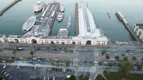 Aerial-view-of-a-waterfront-with-piers,-boats,-and-a-parking-lot,-showcasing-urban-coastal-infrastructure