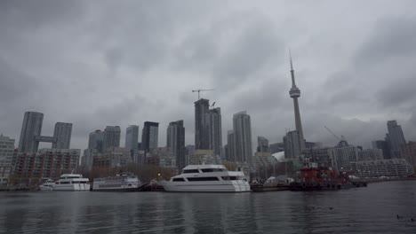 Boats-ships-trawler-docked-pier-tower-city-skyline-buildings-downtown-CBD-Toronto-Harbour-Ireland-Park-Ontario-Canada