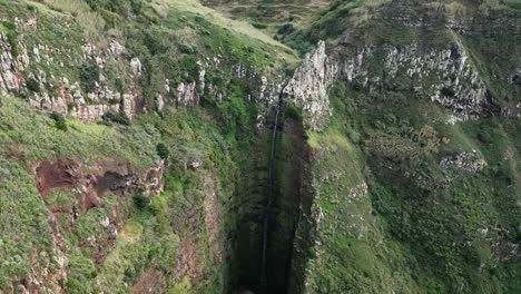 drone-videos-revealing-a-waterfall-between-green-cliffs