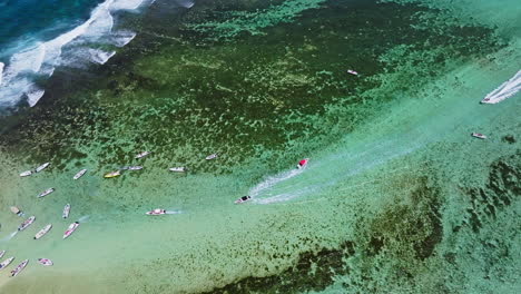 Aerial-drone-view-of-small-boats-speeding-to-reach-small-remote-tropical-island-in-the-ocean