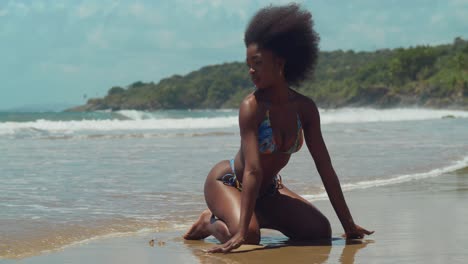 Ein-Bikini-Mädchen-Mit-Lockigem-Haar-Taucht-An-Einem-Sonnigen-Tag-Mit-Meereswellen-Im-Hintergrund-In-Die-Schönheit-Eines-Tropischen-Karibischen-Inselstrandes-Ein