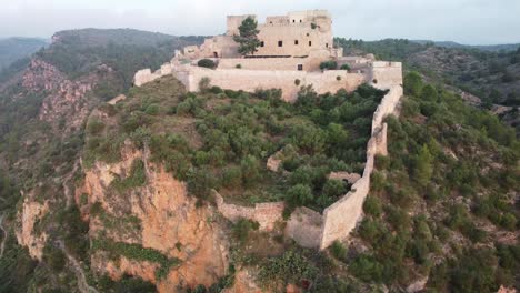 Drone-vertical-shot-of-Miravet-Castle-at-top-of-hill-Tarragona,-spain