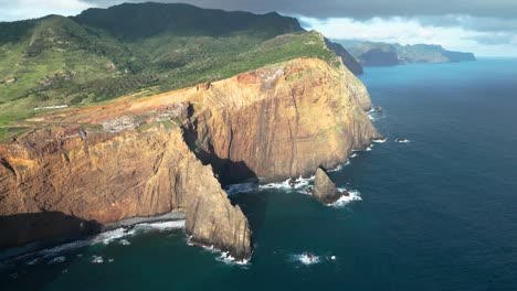 a-sea-cliff-on-the-side-of-an-island-with-waves-hitting-the-shore