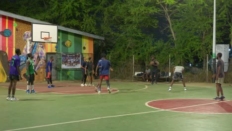 Team-of-black-athletes-play-together-in-basketball-court-outside-at-night-in-africa