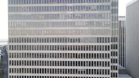 Facade-of-a-modern-office-building-with-a-repetitive-pattern-of-windows-and-architectural-details,-urban-corporate-background