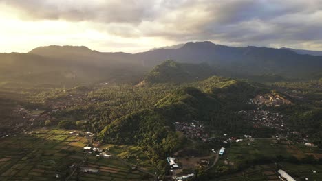 Vista-Cinematográfica-Del-Atardecer-De-La-Cordillera,-Bosques-Tropicales,-Campos-De-Arroz-Y-Pequeños-Pueblos-En-Karangasem,-East-Bai,-Indonesia