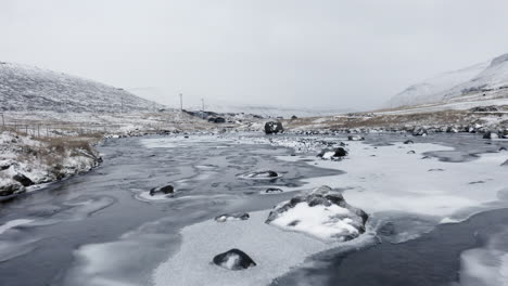 Färöer-Inseln,-4k-Niedrige-Luftaufnahme-über-Einem-Wunderschönen-Schneebedeckten-Fluss