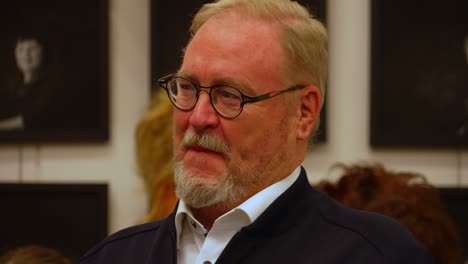 Close-up-of-white-senior-man-with-grey-hair-and-beard-and-glasses-enjoying