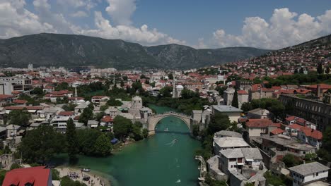 Vista-De-Drones-Para-Deportes-Acuáticos-Sobre-El-Río-En-La-Ciudad-De-Mostar,-Un-Ejemplo-De-Arquitectura-Otomana-En-Bosnia