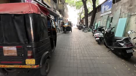 POV-SHOT-Many-bikes-and-four-wheelers-are-parked-in-a-small-street-and-rickshaw-pullers-are-loading-mirrors