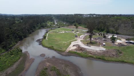 Aerial-view-of-a-recreational-area-with-a-small-river-near-by-with-a-bridge-over-the-river