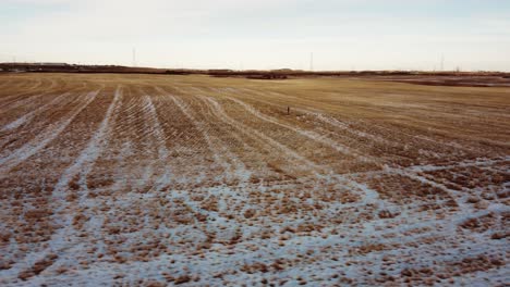 Vista-Aérea-De-Un-Campo-De-Agricultores-Congelado-Cubierto-De-Nieve-En-El-Sur-De-Alberta,-Canadá.