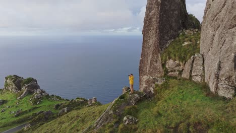 Men-adult-in-yellow-jacket-makes-photo-at-Azores-island-Portugal---Drone-shot